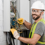 electrician working on electrical panel circuit breaker box