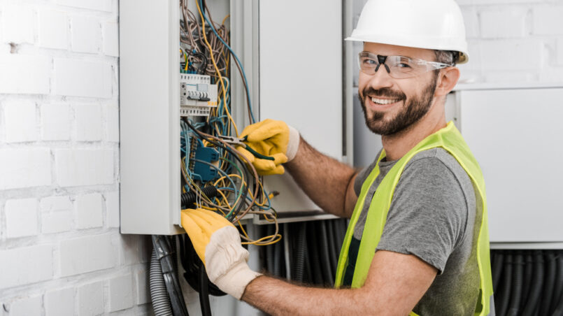 electrician working on electrical panel circuit breaker box